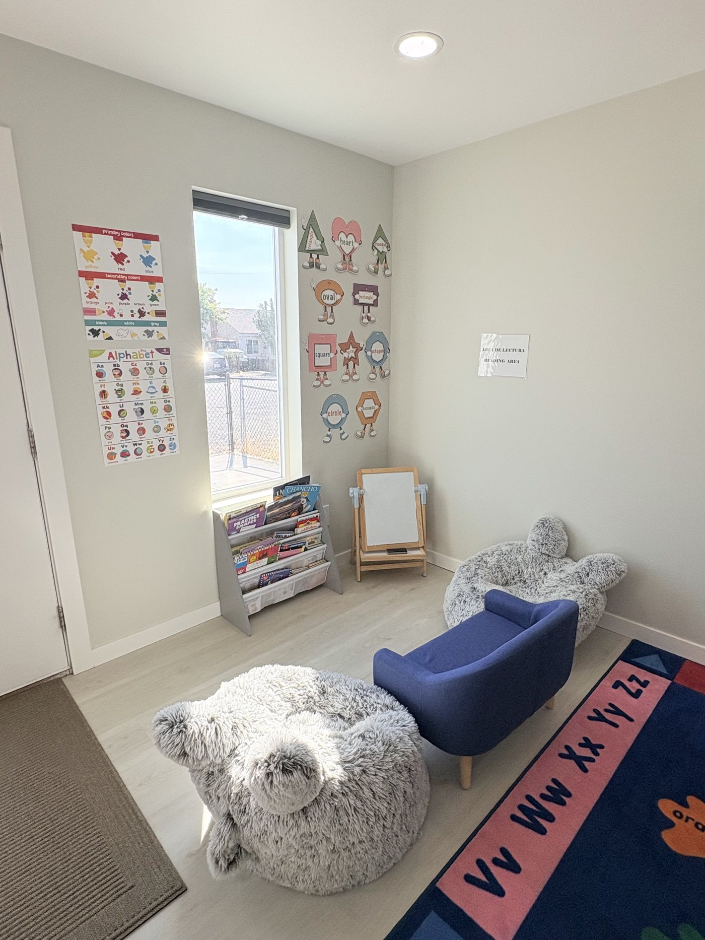 Cozy reading corner with a book display, easel, plush seats and alphabet and color posters